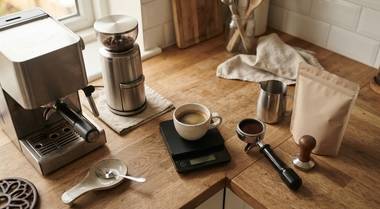 Overhead view of the full cost of a home espresso setup with equipment, ingredients, and receipts